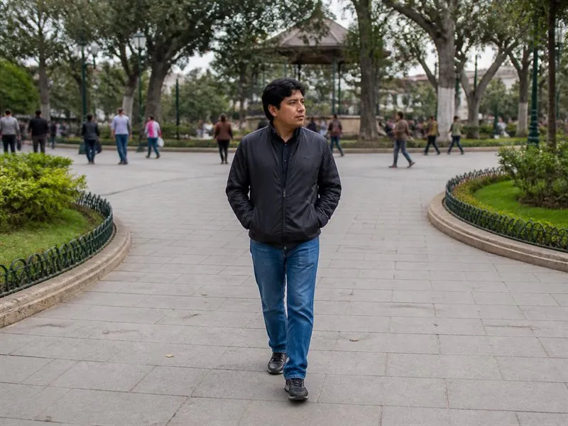 Adulto camina por una plaza cotidiana mientras considera distintas interpretaciones posibles de una situación ambigua.
